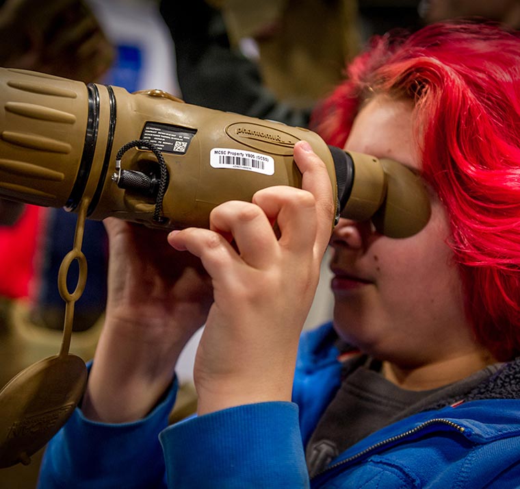 A student using binoculars.